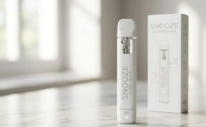 Sleek minimalist Snooze 2G disposable vape pen displayed vertically on a clean marble surface next to its packaging